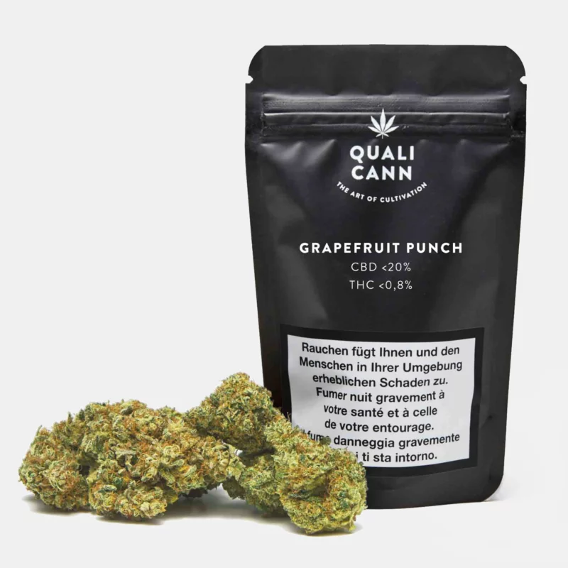 Qualicann Grapefruit Punch CBD-Blütenpackung in Schwarz mit weißen Schriftzügen, davor mehrere CBD-Blüten auf weißem Hintergrund.