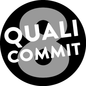 Gute Qualität, Klare Verpflichtung: Ein schwarzer Button mit einer grauen '8' und dem Schriftzug 'Quali Commit', symbolisiert unsere klare Verpflichtung zur herausragenden Qualität unserer Cremes