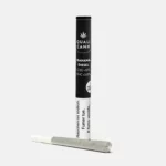 Das Bild zeigt einen CBD-Prerolled Joint der Sorte Banana Diesel von Qualicann, zusammen mit der schwarzen Verpackung.