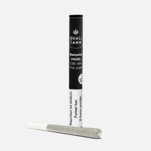 Das Bild zeigt einen CBD-Prerolled Joint der Sorte Banana Diesel von Qualicann, zusammen mit der schwarzen Verpackung.