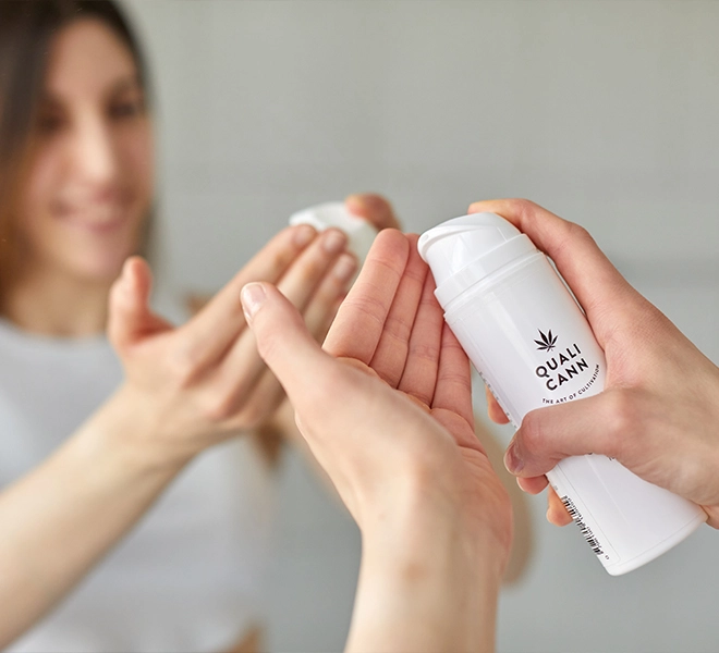 Frau trägt Qualicann CBD Creme auf ihre Hände auf – Symbol für natürliche Hautpflege, Feuchtigkeit und wohltuende Wirkung von CBD-Kosmetik.