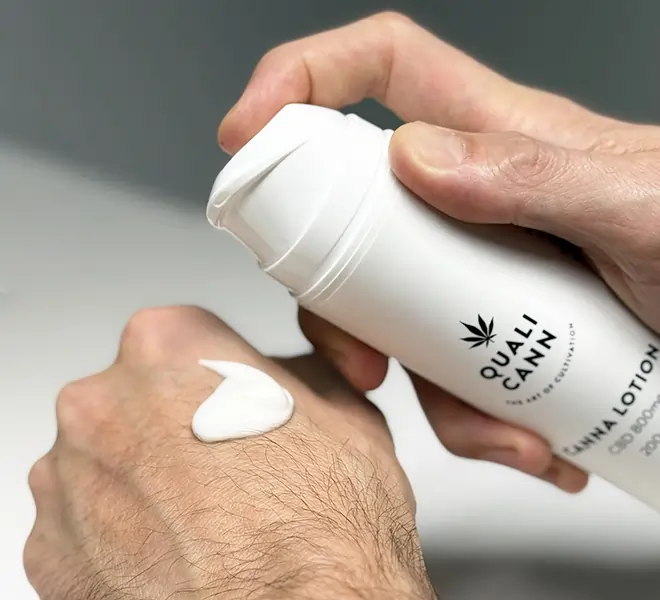 Hand trägt eine Qualicann Canna Lotion mit CBD auf die Haut auf – moderne CBD-Kosmetik im praktischen Pumpspender für Pflege- und Wellness-Routinen