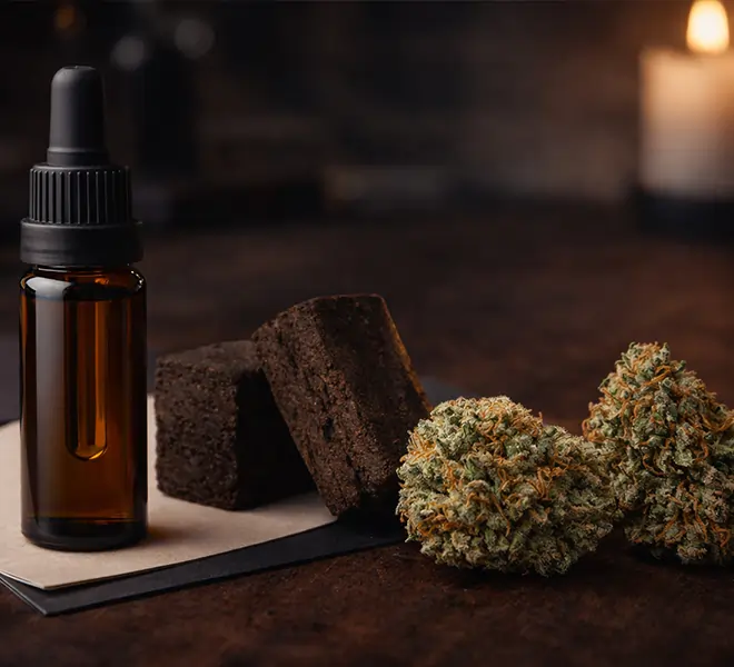 CBD &Ouml;l Flasche mit CBD Hasch und CBD Bl&uuml;ten auf dunkler Oberfl&auml;che