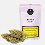 Grüne Cannabisblüte mit orangefarbenen Härchen vor einer Bubble Gum Verpackung von Qualicann auf hellem Hintergrund