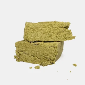 Zwei helle bröselige CBD Pollen Stücke in Blockform auf hellem Hintergrund