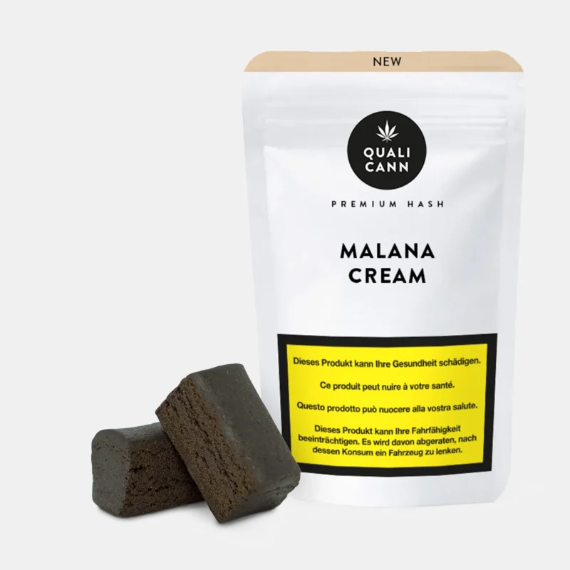 Zwei dunkle Hashstücke vor weissem Verpackungsbeutel mit Aufschrift Malana Cream von Qualicann