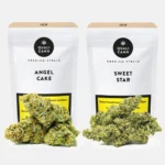 Zwei weiße Verpackungen mit den Aufschriften ‚Angel Cake‘ und ‚Sweet Star‘ neben hellgrünen Cannabisblüten mit orangefarbenen Härchen