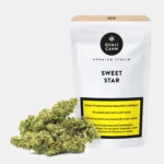 Qualicann Sweet Star CBD Blüten mit Cannabis CBD Blüten vor weisser Qualicann Verpackung